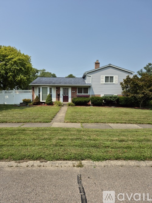A house with a grey roof and a white fence.