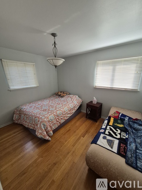 A bedroom with a bed and a chair.
