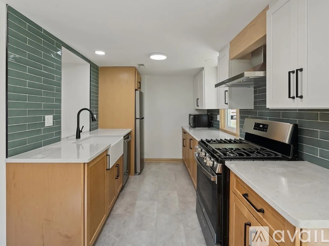 A kitchen with wooden cabinets and a black stove top oven.