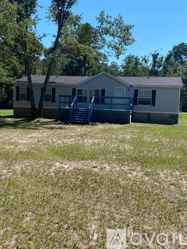 A mobile home with a deck and a backyard.