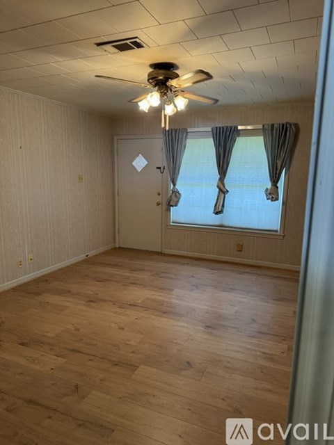 A room with wooden flooring and a ceiling fan.