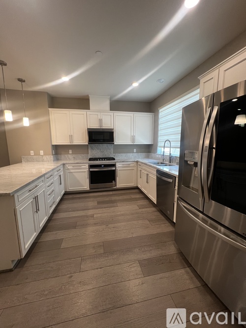A kitchen with white cabinets and stainless steel appliances.