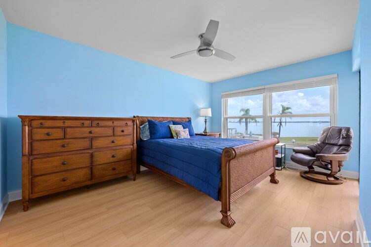 A bedroom with a bed, dresser, and chair.