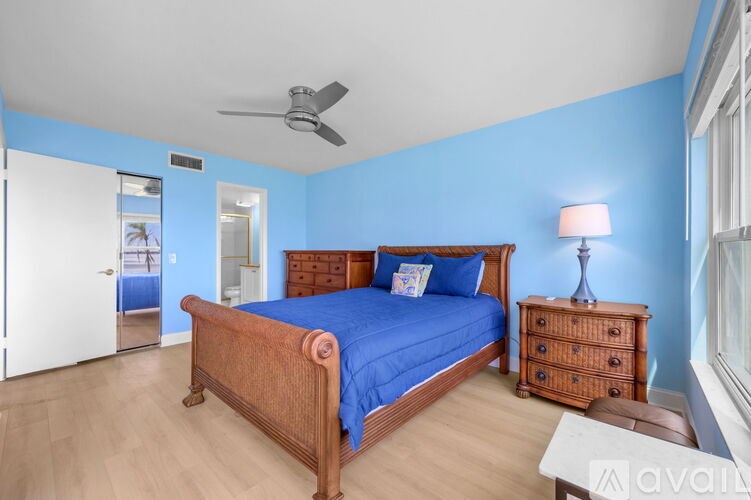 A bedroom with a bed, nightstand, and dresser.