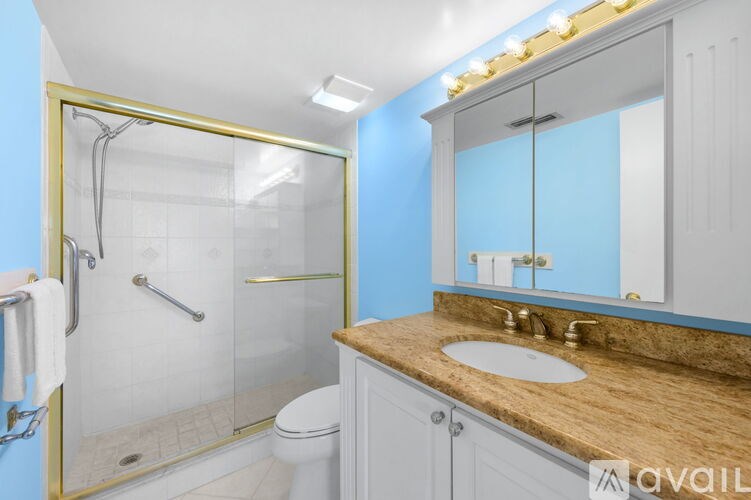 A bathroom with a toilet, sink, and shower.