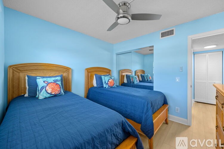 Two twin beds with blue bedspreads in a room with blue walls.