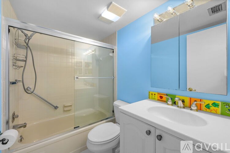 A bathroom with a blue wall and a white sink.