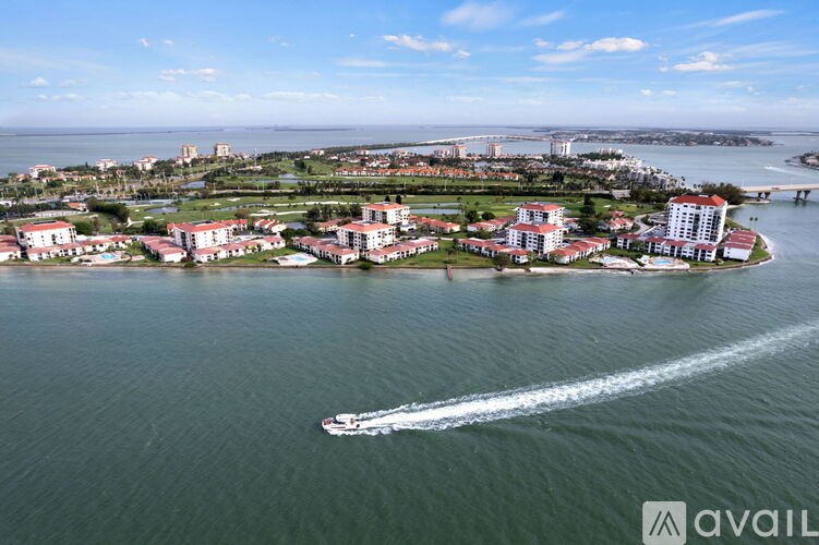 A boat is sailing in the water near a coastal city.