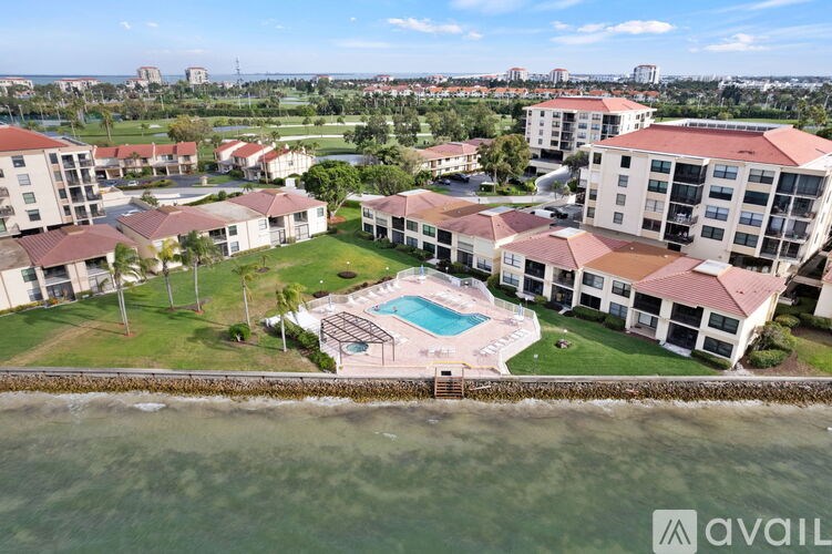 An aerial view of apartment buildings with a pool in the foreground.