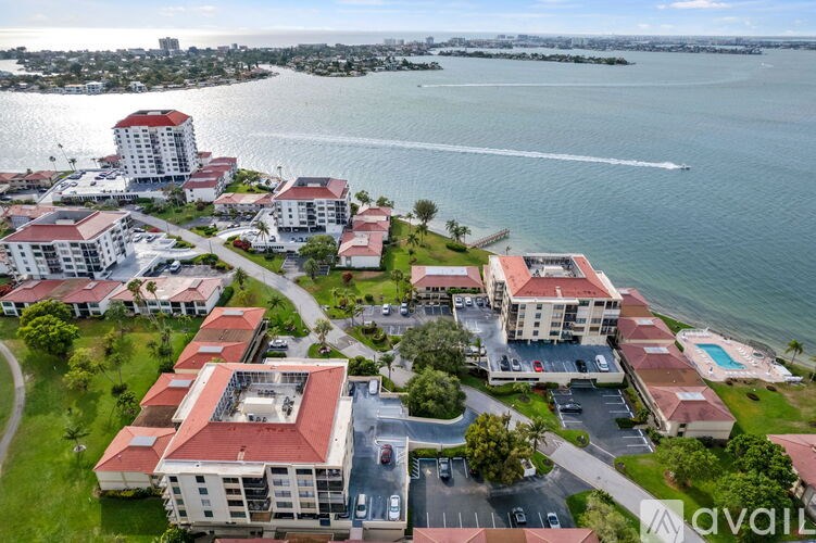A bird's eye view of a resort with a large body of water in front.