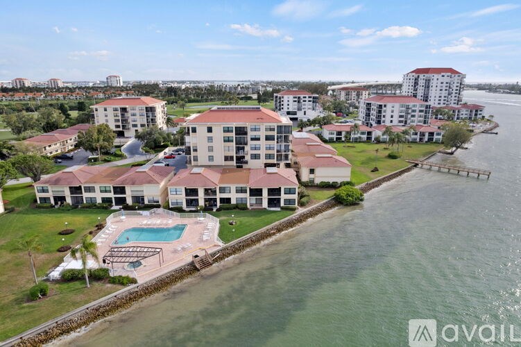 A large building with a pool in front of it is surrounded by water.