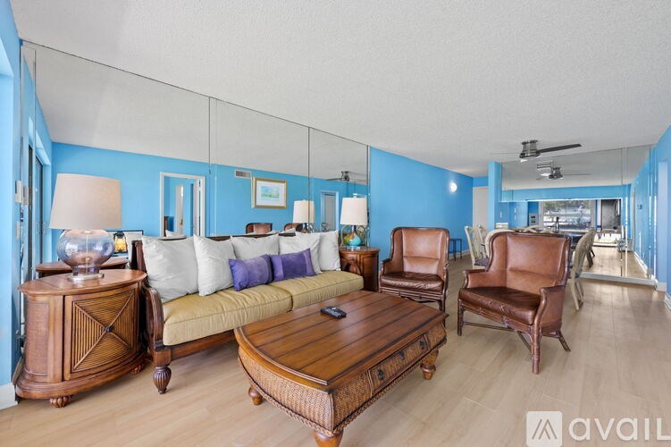 A living room with a sofa, chairs, and a wooden coffee table.