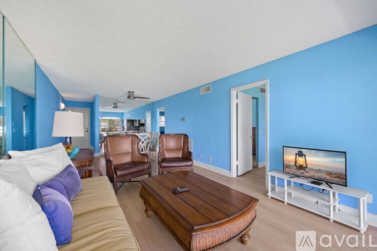 A living room with a white couch and a wooden coffee table.