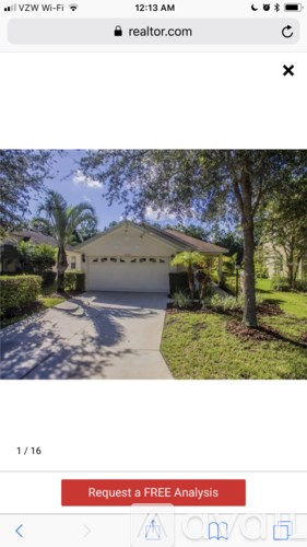 A house with a driveway and trees in front.