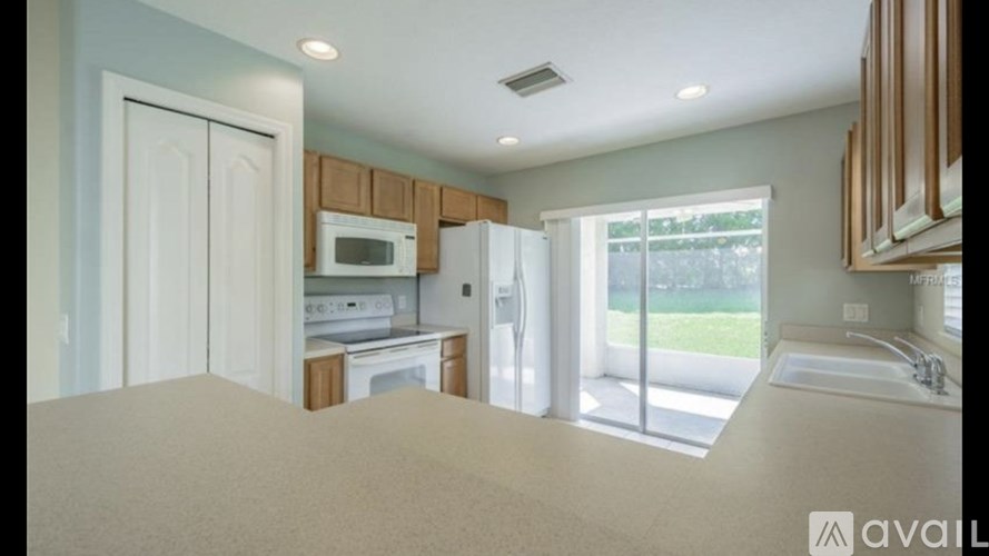 A kitchen with white appliances and wooden cabinets.