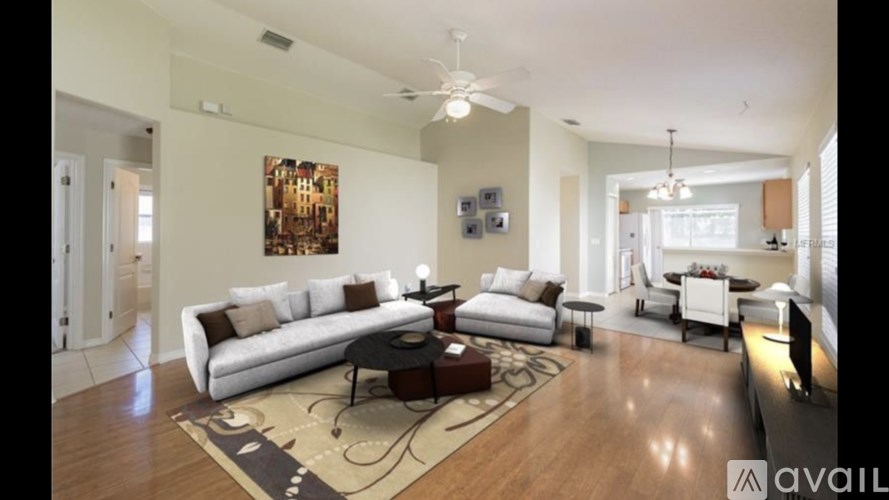 A living room with a white couch and a rug.