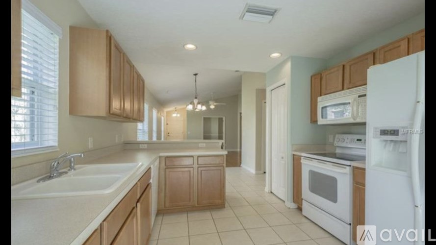 A kitchen with wooden cabinets and white appliances.