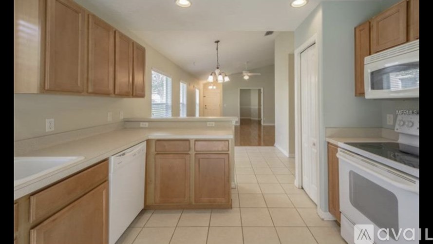 A kitchen with wooden cabinets and white appliances.