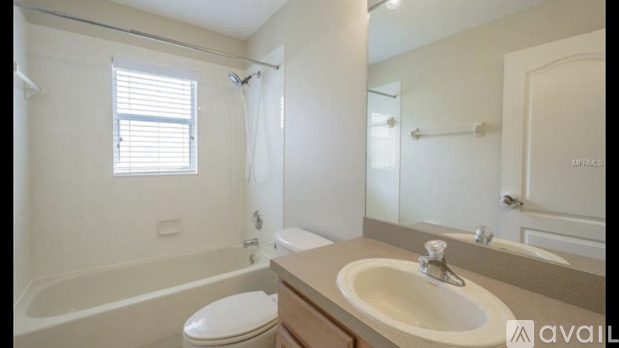A bathroom with a white toilet, sink, and bathtub.