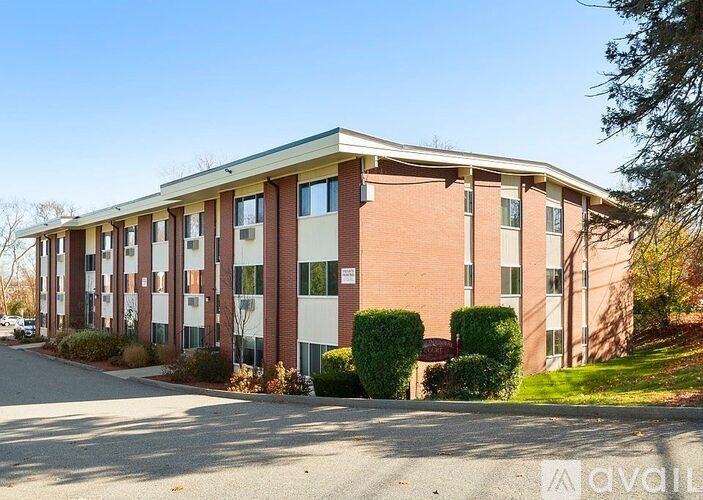 A large apartment building with a parking lot in front.