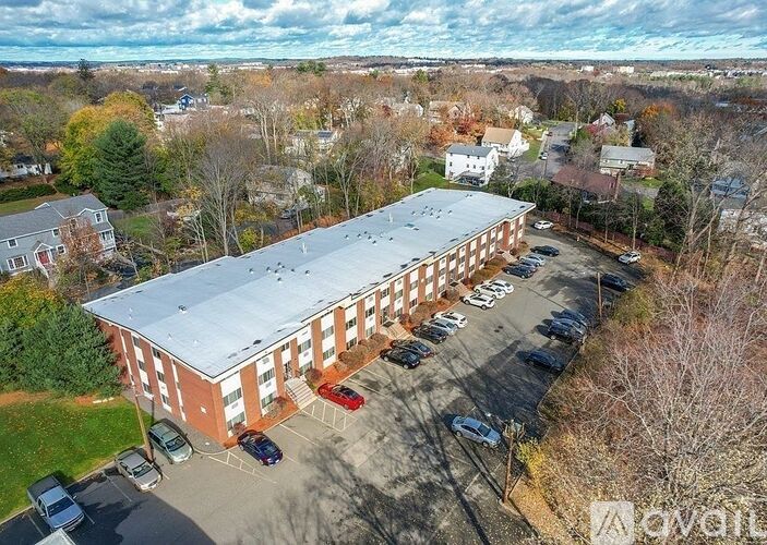 An aerial view of a parking lot in front of a red brick building.