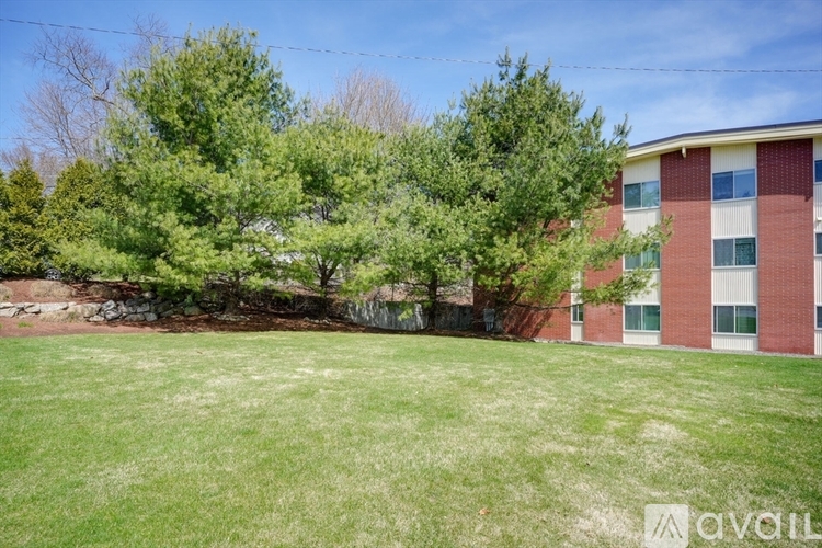 A grassy field in front of a red brick building.