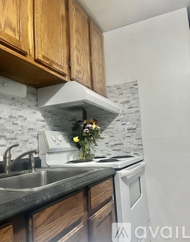 A kitchen with a white stove and wooden cabinets.