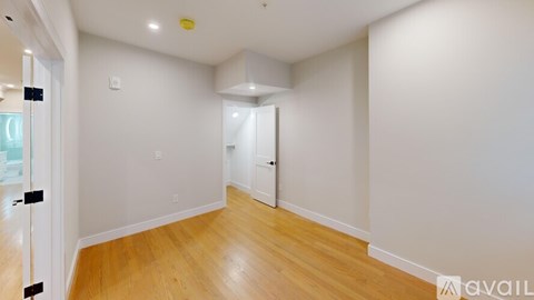 A room with wooden flooring and white walls.