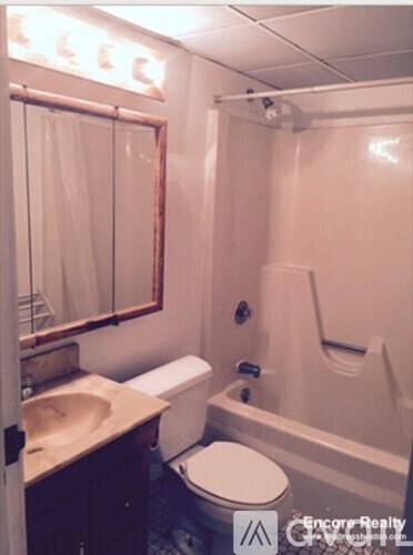 A bathroom with a toilet, sink, and bathtub.