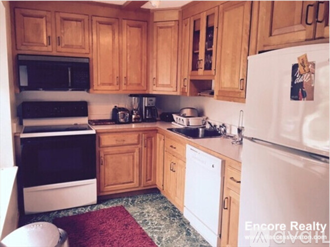 A kitchen with wooden cabinets and a white fridge.