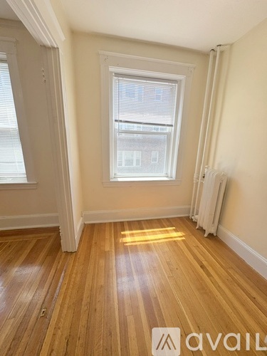 A living room with a wooden floor and a large window.