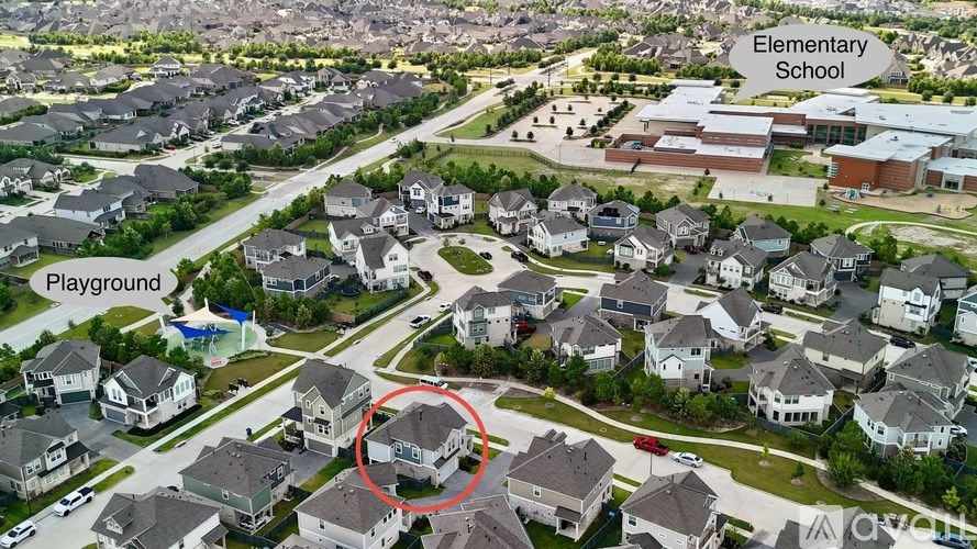 An aerial view of a neighborhood with a playground and an elementary school.