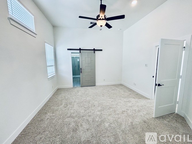 A room with a ceiling fan and a door with a window.