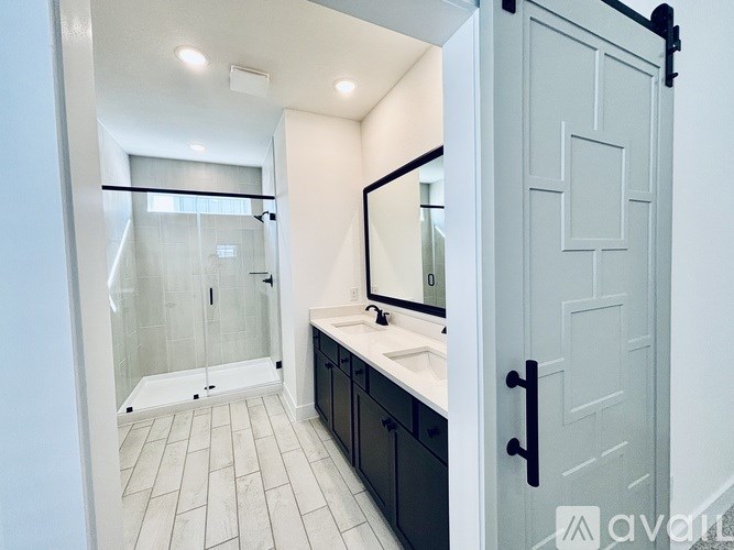 A bathroom with a white door and black handles.
