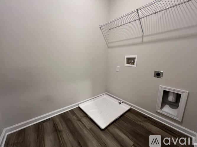 A room with a chandelier, wooden floor, and white wainscoting.