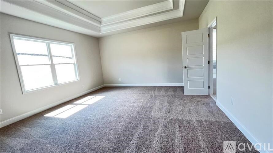 A room with a carpeted floor and a door on the right side.