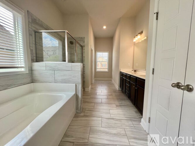 A bathroom with a white tub and tiled floor.