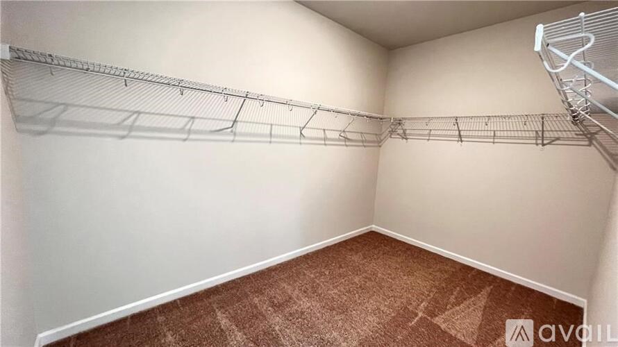 A room with a carpeted floor and a metal rack on the wall.