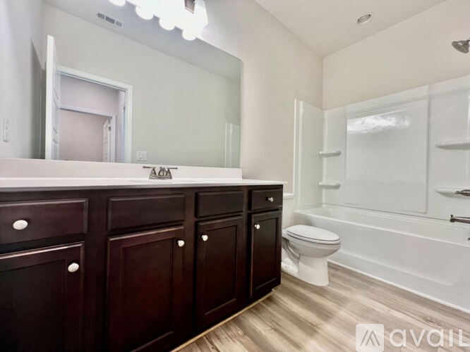 A bathroom with a toilet, sink, and mirror.