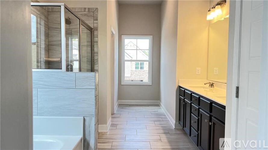 A bathroom with a tub, sink, and a window.
