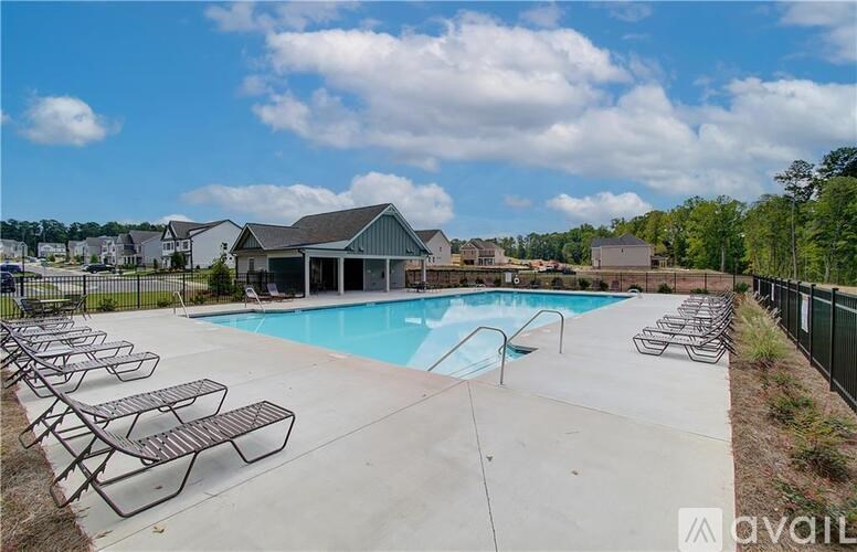 A pool surrounded by chairs and a fence.