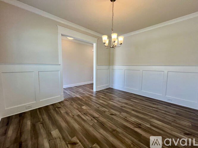 A long hallway with a window and a door at the end.