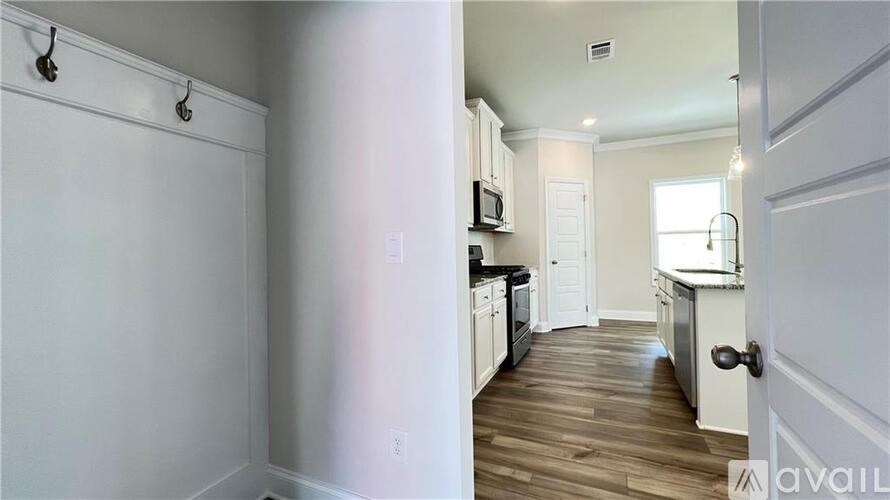 A kitchen with white cabinets and a white door.