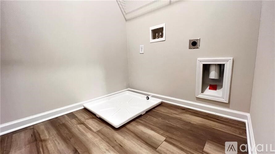 A room with a white floor mat and a small white door.