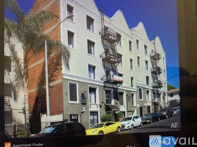Apartment building with a yellow car parked in front.