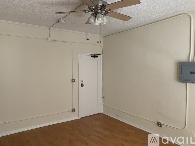 A room with a ceiling fan and a door.