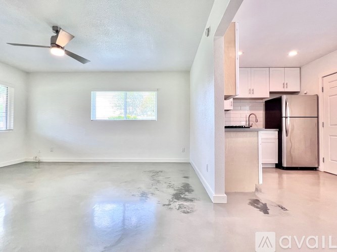 A spacious kitchen with white cabinets and a refrigerator.