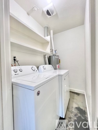 A white washing machine and dryer in a small laundry room.