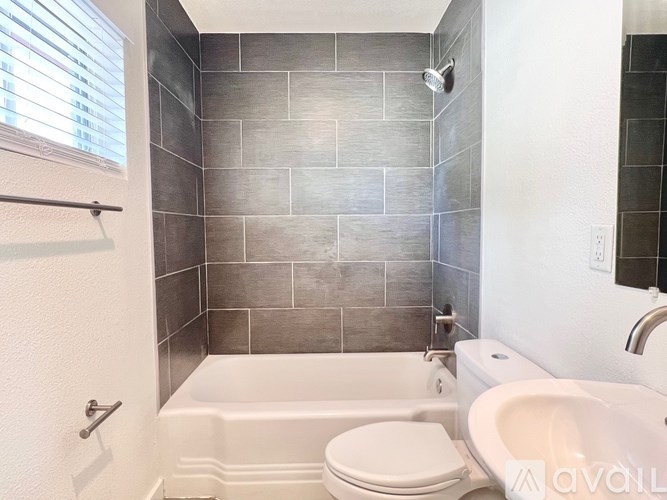 A bathroom with a white tub, toilet, and sink.