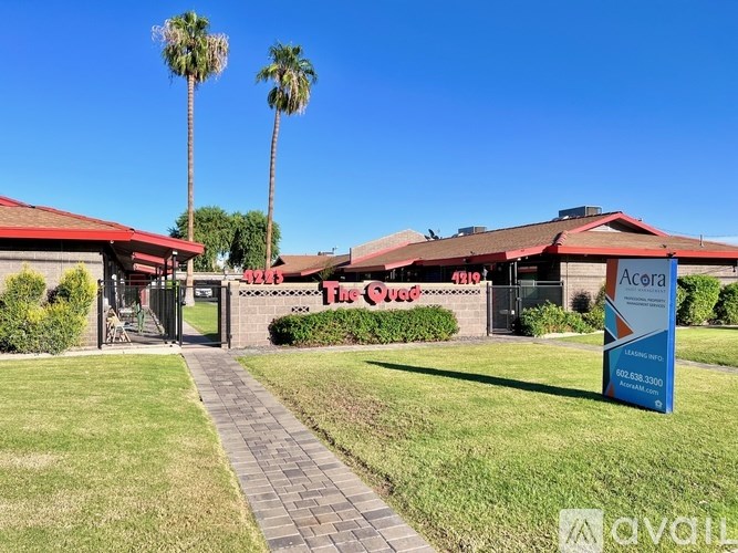 A red building with palm trees in front of it.